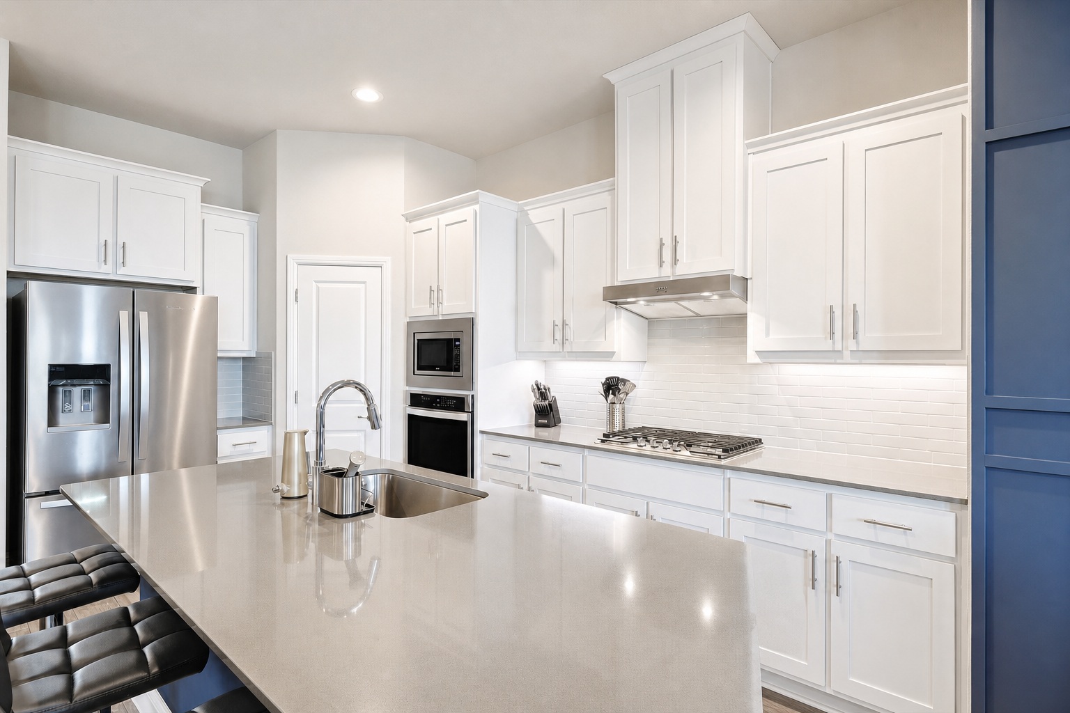 Gourmet kitchen with white cabinets and quartz countertops